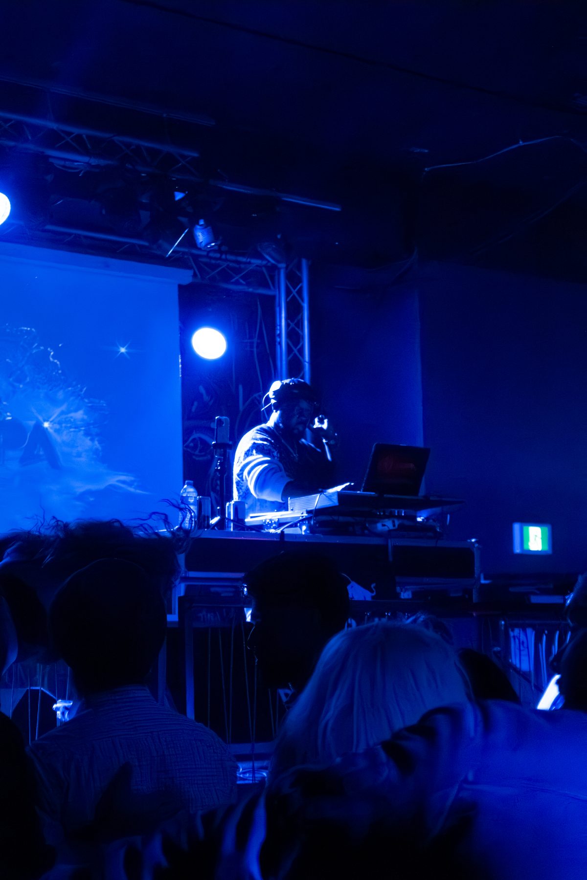 Artist lit by a deep blue stage wash