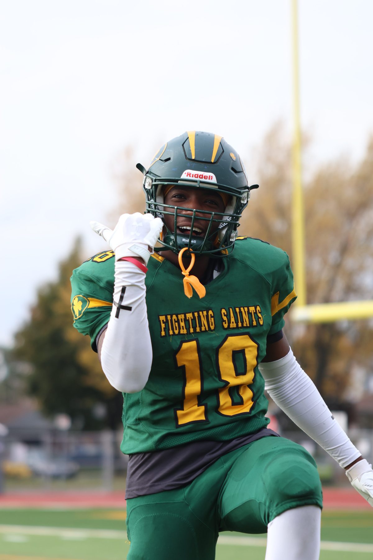 Football player in a green helmet on the sideline