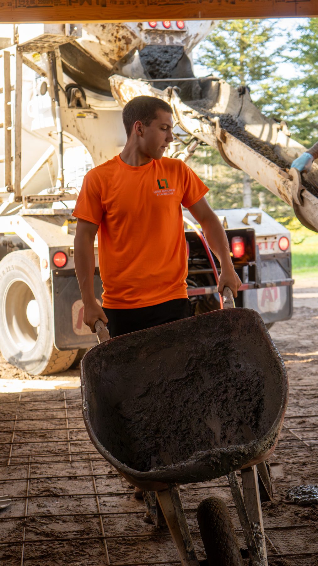 Tradesperson in an orange shirt lifting material on a residential build